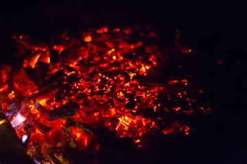 Fototapeta na wymiar Burning embers of a fire on a black background.