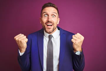 Young handsome business man over purple isolated background celebrating surprised and amazed for success with arms raised and open eyes. Winner concept.