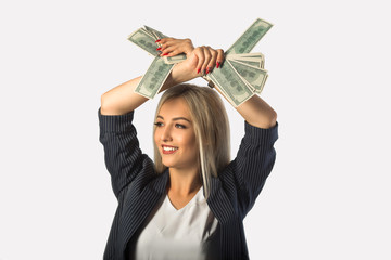 beautiful young woman in a suit on a white background with dollars in hands