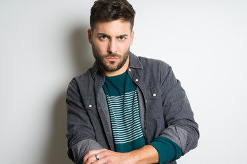 Young handsome man possing and modeling over grey isolated background