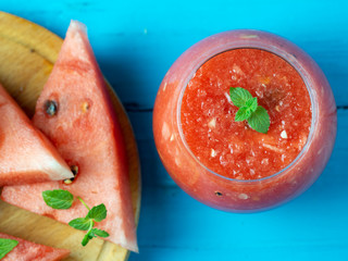 Fresh watermelon smoothie on wooden blue background .
