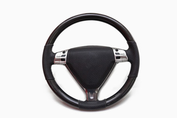 Sports car steering wheel with multi-function control buttons made of leather and carbon fiber on a white isolated background