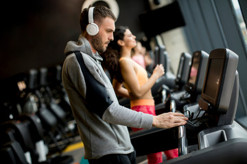 Fototapeta na wymiar Young people using threadmill in modern gym