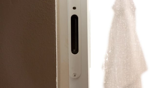 Cerrando una ventana corrediza blanca con asa negra