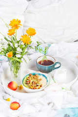 Bowl of fresh oatmeal porridge with kiwi, peach and granola