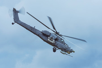 Fototapeta premium Military combat helicopter flies rapidly turning in the air.