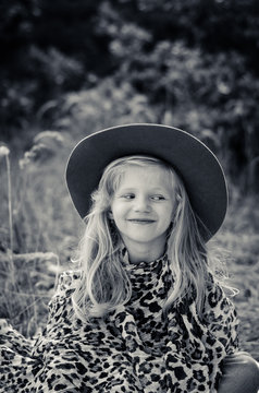 little child  with long blond hair and hat