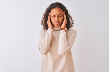 Young brazilian woman wearing turtleneck sweater standing over isolated white background with hand on head for pain in head because stress. Suffering migraine.