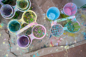 Poster color and plastic palette with colorful paints on recycle paper.