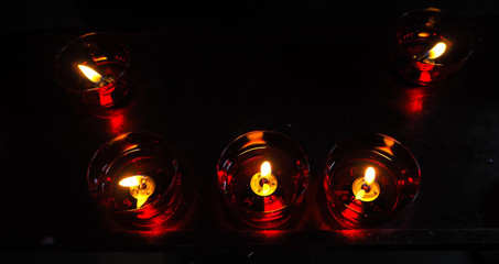 Living light candles in church