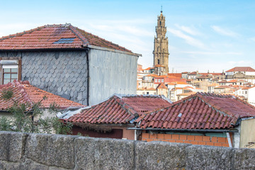 Porto panoramic landmark with church tower on sunny day. Old buildings with red brick roofs in...