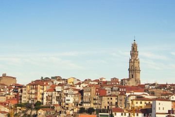 Fototapeta na wymiar Porto panoramic landmark with church tower on sunny day. Old buildings with red brick roofs in Porto, Portugal. Historic district of Porto. Portuguese vacation. 