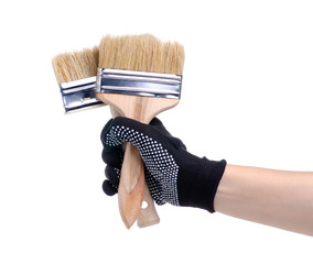 Hands in working gloves holding building paint brush on white background isolation