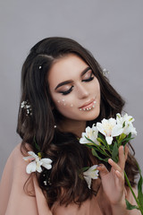 Naklejka premium Close-up portrait of a sensual spring lady with flowers. Beauty, cosmetics. Make-up