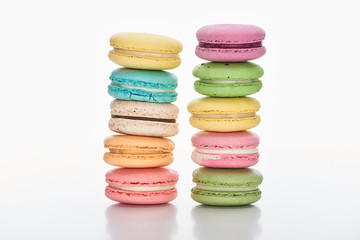 two rows of sweet multicolored French macaroons of different flavors on white background