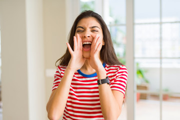 Fototapeta na wymiar Beautiful young woman shouting and screaming with hand on mouth very excited