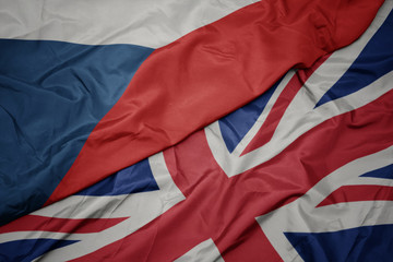 waving colorful flag of great britain and national flag of czech republic.