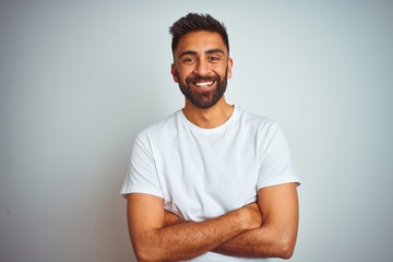 Young indian man wearing t-shirt standing over isolated white background happy face smiling with...