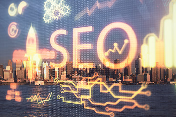 SEO hologram on city view with skyscrapers background double exposure. Search optimization concept.