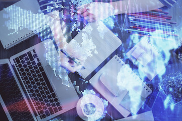 Financial forex graph drawn over hands taking notes background. Concept of research. Double exposure