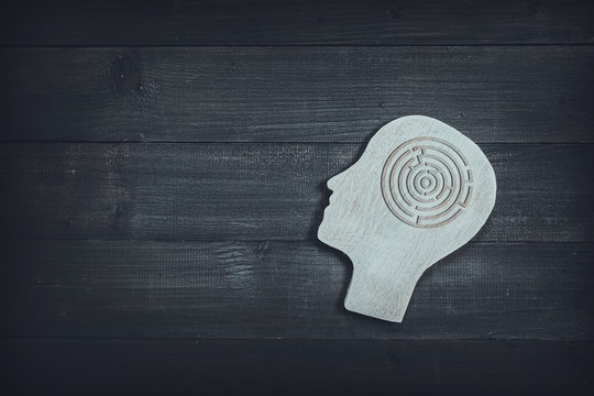 Human head and face with circle maze sign on wood table background. Brain of thinking about solving problem , Symbol of Process and Positive Mind concept