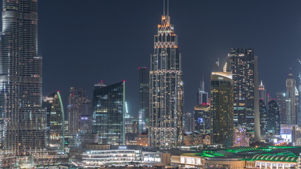 Aerial nighttime cityscape with illuminated architecture of Dubai downtown timelapse, United Arab Emirates.