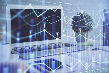 Stock market graph and table with computer background. Double exposure. Concept of financial analysis.