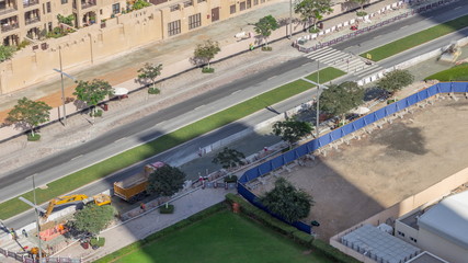 Excavator, truck and grader working at road construction site in Dubai downtown timelapse