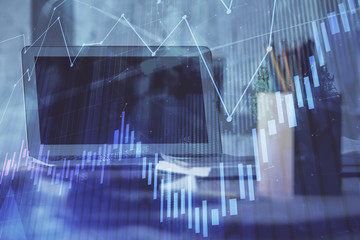 Stock market graph on background with desk and personal computer. Double exposure. Concept of financial analysis.