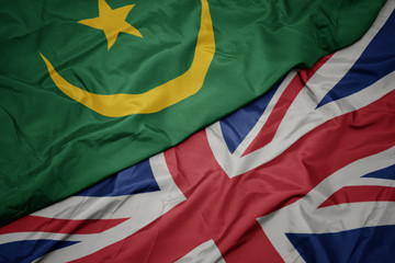 waving colorful flag of great britain and national flag of mauritania.