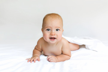 Beautiful wet babe smiles on the white bad wiht clean sheet.