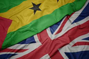 waving colorful flag of great britain and national flag of sao tome and principe.