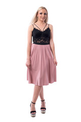 Beautiful blonde tender affectionate woman holding pleated skirt looking at camera. Full body isolated on white background. 