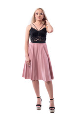 Confident young stylish blonde woman in summer skirt and lace top touching hair looking at camera. Full body isolated on white background. 