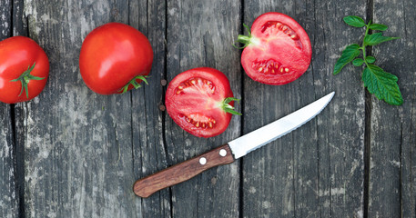 .tomatoes and knife on a wooden background
