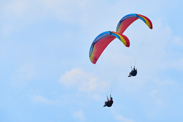 Paraglider flying over the Garda Lake (Lago di Garda or Lago Benaco), Panorama of the gorgeous Garda lake surrounded by mountains. Paragliding is very popular sport in Monte Baldo. Malcesine, Italy