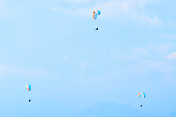 Paraglider flying over the Garda Lake (Lago di Garda or Lago Benaco), Panorama of the gorgeous Garda lake surrounded by mountains. Paragliding is very popular sport in Monte Baldo. Malcesine, Italy