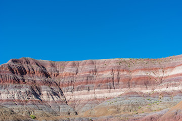 Landscape of red, orange, pink and white striped or banded hills at Paria Canyon in Grand Staircase Escalante National Monument