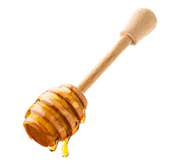 Honey drips down the wooden stick close-up on a white. Isolated.
