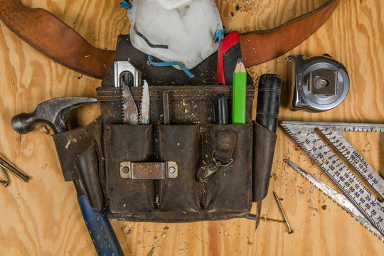 Carpentry tools on a wooden background at jobsite.  construction, carpentry, tools toolbelt 