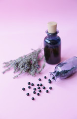 Homeopathic balls in a glass bottle and essential oil in a bottle and lavender herb on a blue background Alternative medicine Herbal homeopathy. Aromatherapy. With copy space or image.