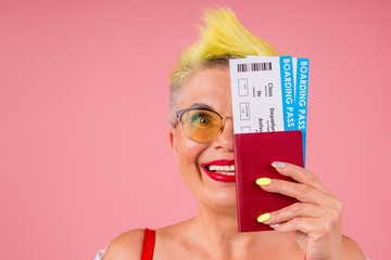 caucasian beautiful old senior with stylish yellow dyed hair and sunglasses holding passport and...