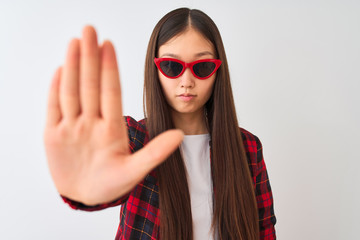 Young chinese woman wearing casual jacket and sunglasses over isolated white background with open hand doing stop sign with serious and confident expression, defense gesture