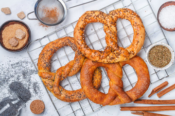 Pretzel. Freshly baked pretzels with sugar, poppy seeds, cinnamon and cumin. Delicious homemade sweet and salty pastries and ingredients on the table. Selective focus, top view