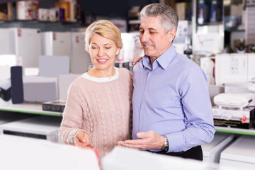 Husband and wife in home appliance store to discuss items