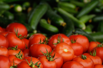 Ripe tomatoes and cucumbers in natural light on the counter. The concept is an oriental bazaar. Healthy eating