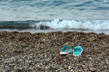 Mediterranean Sea. Dawn. At the water's edge are beach shoes in the sand