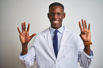 Young african american doctor man wearing coat standing over isolated white background showing and pointing up with fingers number nine while smiling confident and happy.