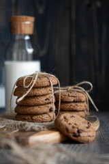 Chocolate chip cookies and milk on wooden background