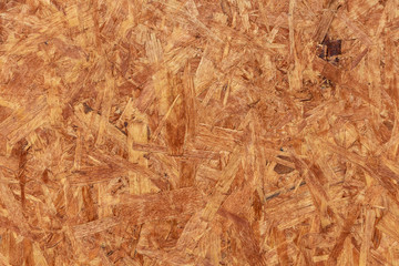 A horizontal texture of yellow chipboard for construction with knots